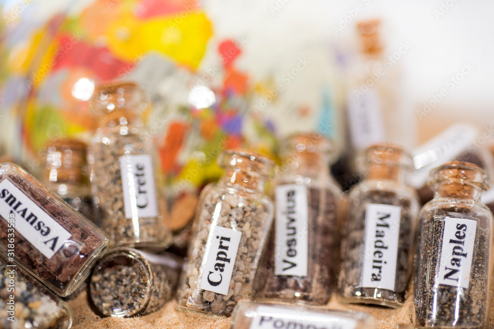 Glass test-tube with sand of different summer vacation countries. Located in sand with small globe. Glass test-tube with sand of different summer vacation countries. Located in sand with small globe.