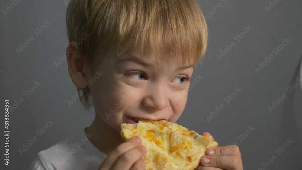 The boy is eating pizza. Unhealthy diet. Fast food home The boy is eating pizza. Unhealthy diet. Fast food home