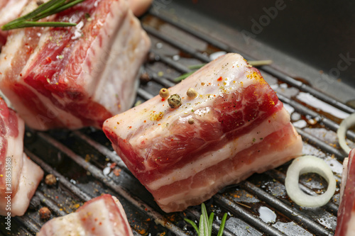 Grill pan with raw ribs and seasonings, closeup