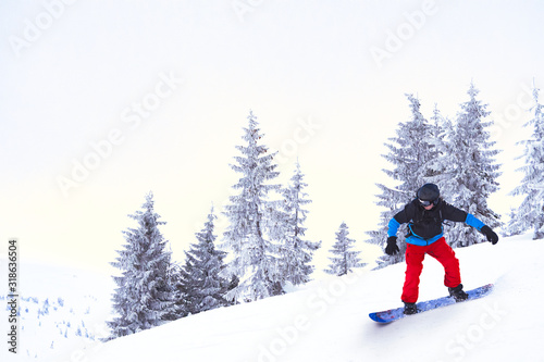 Snowboarder Riding Snowboard in the Beautiful Mountains. Snowboarding and Winter Sports Concept