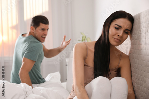 Couple with relationship problems quarreling in bedroom