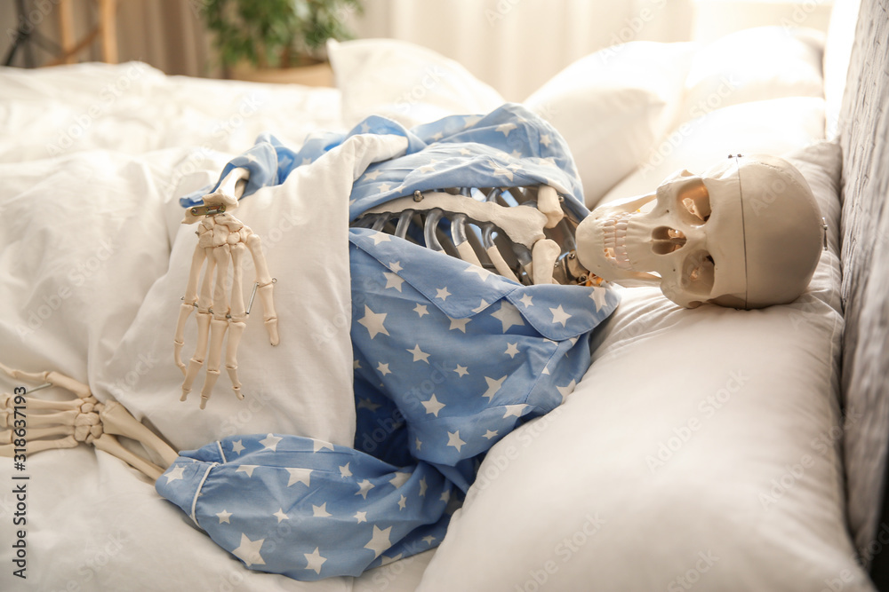 Human skeleton in pajamas lying on bed indoors Stock Photo | Adobe Stock