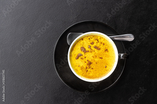 Serving of aromatic turmeric black coffee against dark table