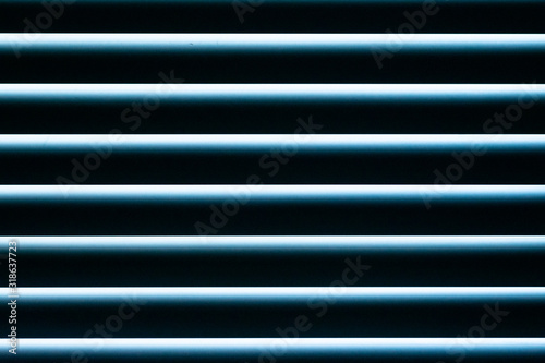 a closeup of closed accordion style blinds on a sunny day 