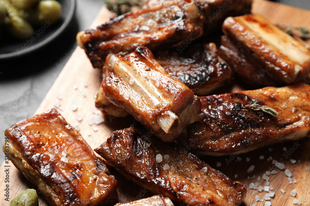 Delicious grilled ribs served on table, closeup Delicious grilled ribs served on table, closeup