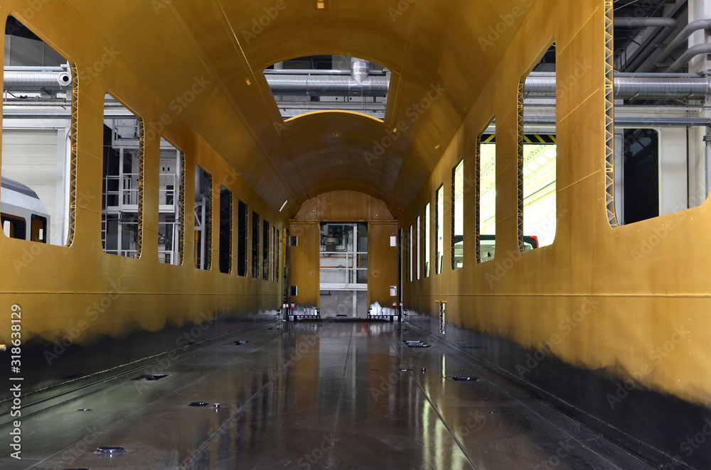 Obraz premium Inside of the rail car assembly plant. Industrial workshop for the production of high speed trains. Factory of the manufacturing trainsets passenger rolling stock. Paint shop