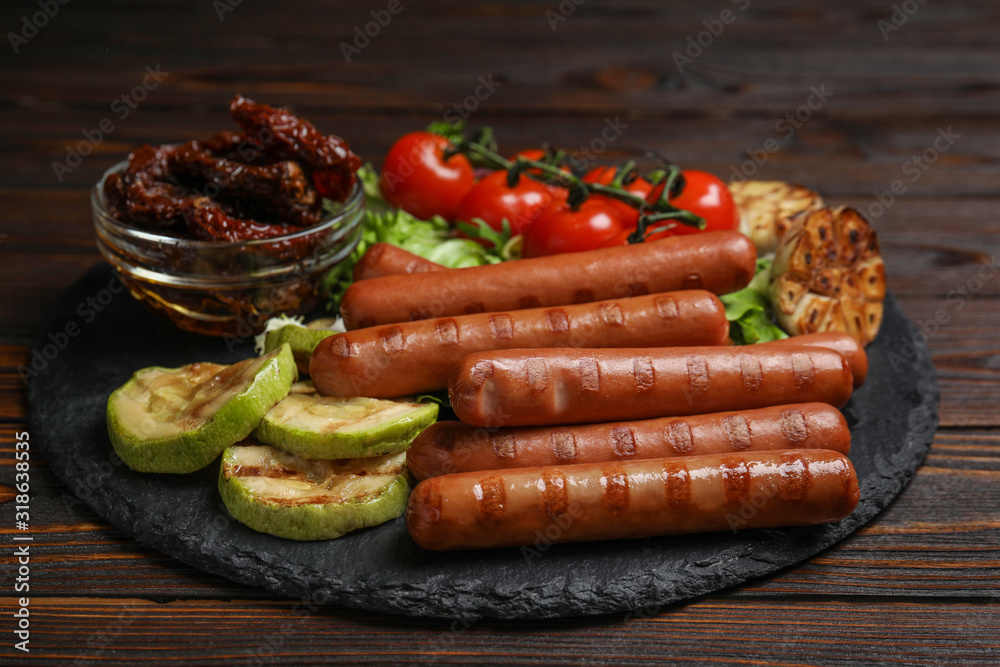 Delicious grilled sausages served on wooden table Delicious grilled sausages served on wooden table