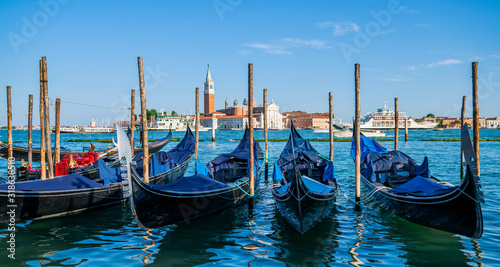 Gondolas moored by Saint Mark square. Old pier. Architecture and landmarks of Venice. Vacation and holidays in Italy and Europe concept.