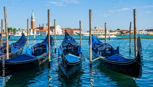 Gondolas moored by Saint Mark square. Old pier. Architecture and landmarks of Venice. Vacation and holidays in Italy and Europe concept.