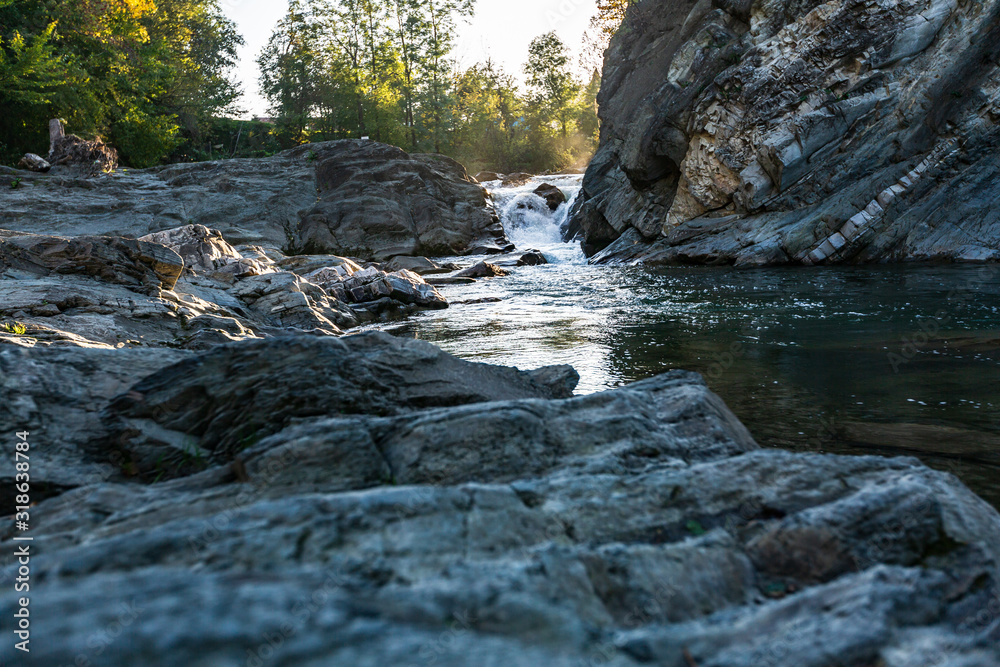 raging threshold on a river flowing among the rocky shores in the forest on a fine day raging threshold on a river flowing among the rocky shores in the forest on a fine day