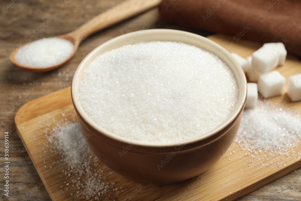 Granulated sugar in bowl on wooden table Granulated sugar in bowl on wooden table