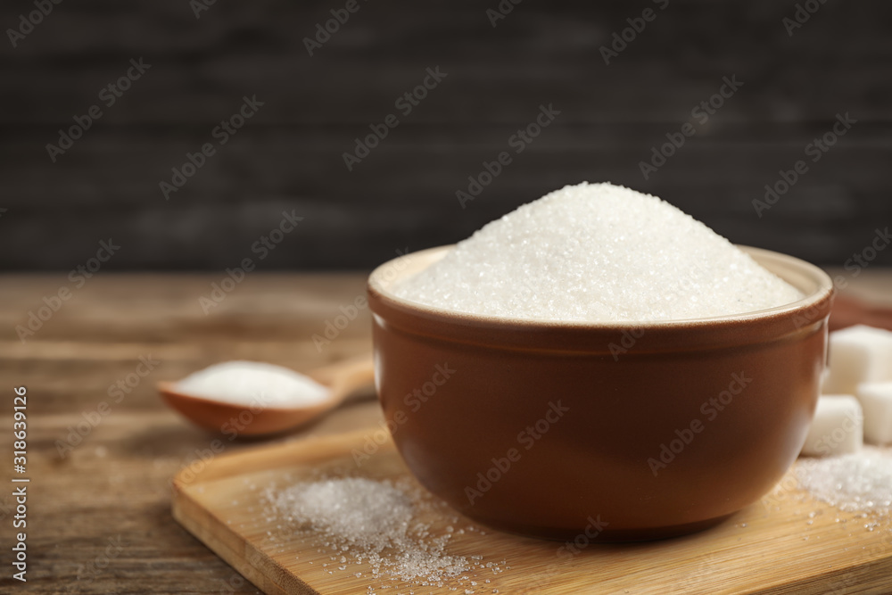Granulated sugar in bowl on wooden table Granulated sugar in bowl on wooden table