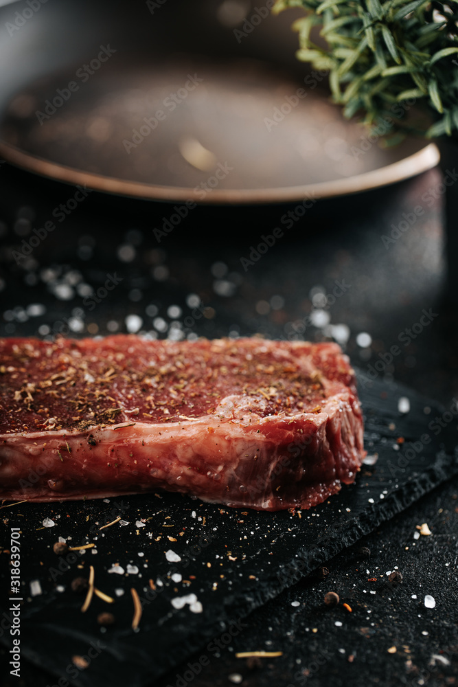 Sirloin steak preparation, seasoning with pepper and salt. Chef preparing fresh meat on dark marble plare. Sirloin steak preparation, seasoning with pepper and salt. Chef preparing fresh meat on dark marble plare.