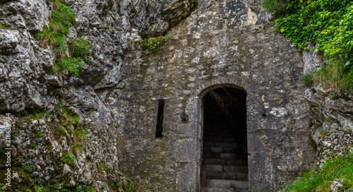 Fototapeta Naklejka Na Ścianę i Meble -  Exterior of the entrance to the citadel of Sisteron, rock fortress in the south of France, Europe. Listed as UNESCO World Heritage Site. Stone wall with traces of weathering and destruction.
