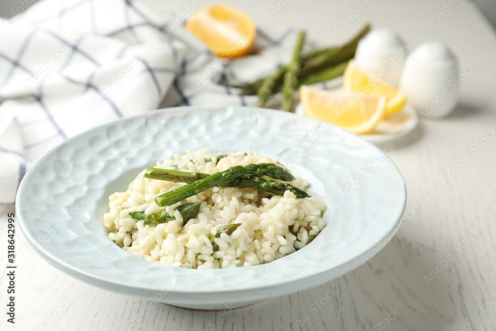Delicious risotto with asparagus on white wooden table Delicious risotto with asparagus on white wooden table