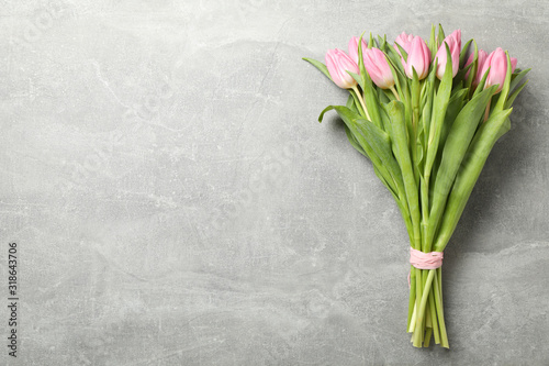 Bouquet of pink tulips on grey background, space for text