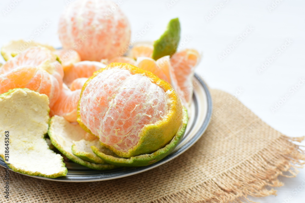  Natural, whole, chopped tangerines on wooden background
