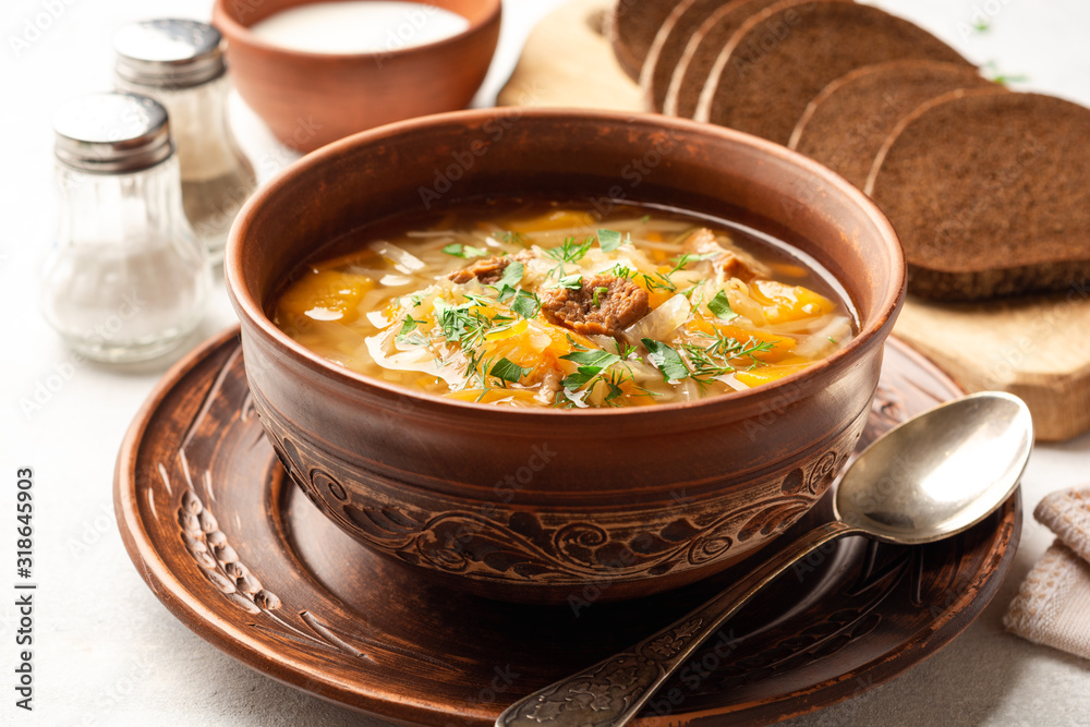 Traditional russian cabbage soup with turnip shchi in ceramic bowl on concrete background. Selective focus. Traditional russian cabbage soup with turnip shchi in ceramic bowl on concrete background. Selective focus.