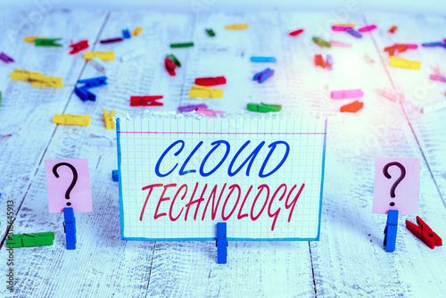 Conceptual hand writing showing Cloud Technology. Concept meaning on deanalysisd availability of computer system resources Crumbling sheet with paper clips placed on the wooden table photo