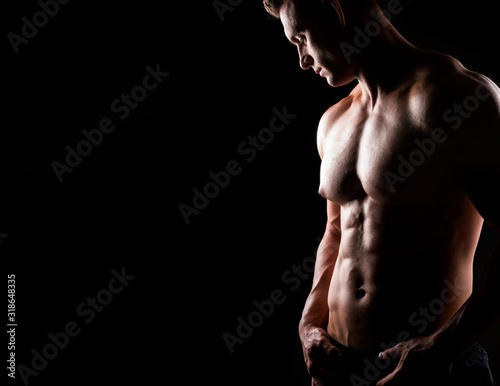 Strong, fit and sporty bodybuilder man over dark background. Sport and fitness.