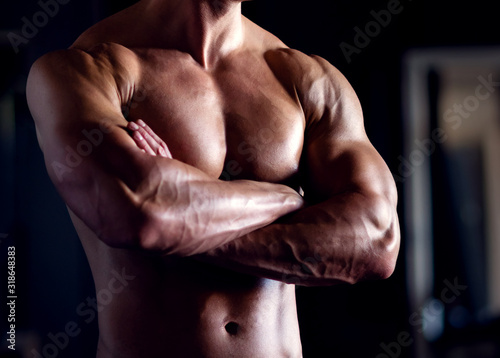 Strong, fit and sporty bodybuilder man over black background.