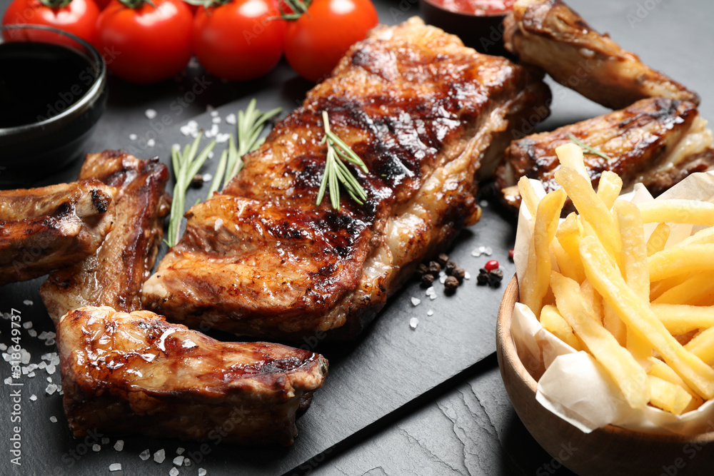 Delicious grilled ribs on black table, closeup