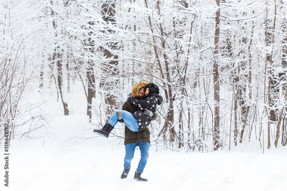 Happy loving couple having fun outdoors in snow park. Winter vacation