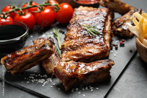 Delicious grilled ribs on black table, closeup