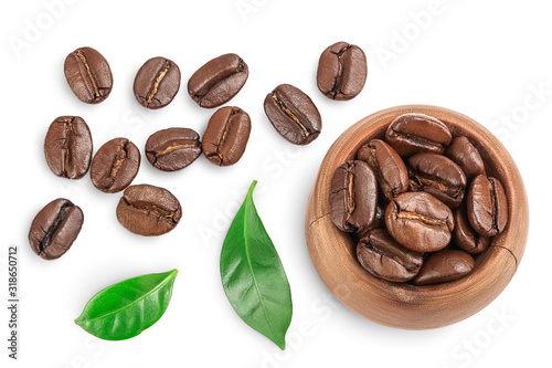 Heap of roasted coffee beans in wooden bowl with leaves isolated on white background with clipping path and full depth of field. Top view. Flat lay.