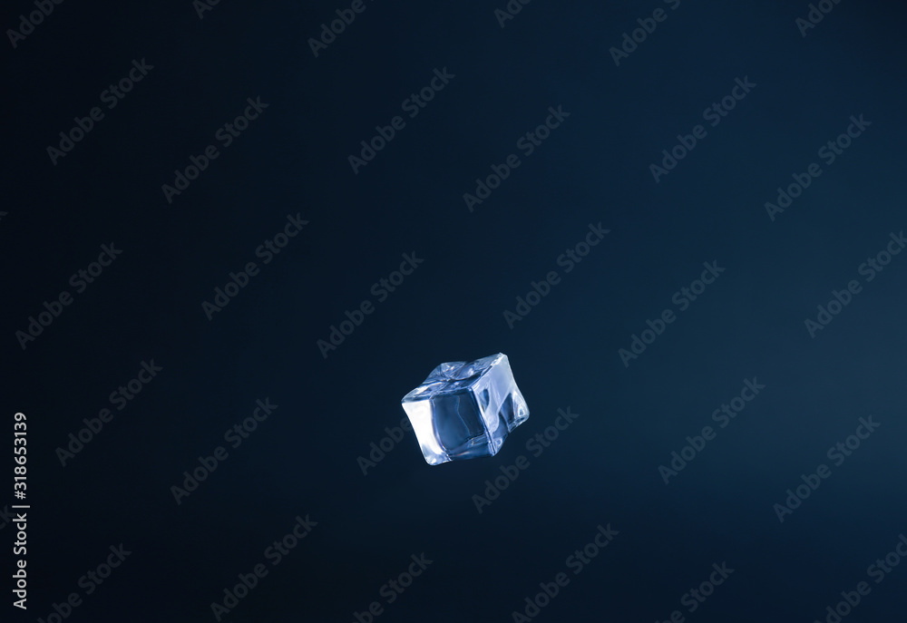 Fototapeta premium Crystal clear ice cube on dark blue background