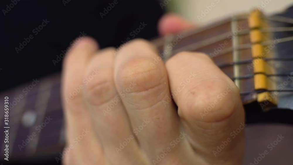 A man plays the guitar, puts his finger on the strings, a chord. A man plays the guitar, puts his finger on the strings, a chord.