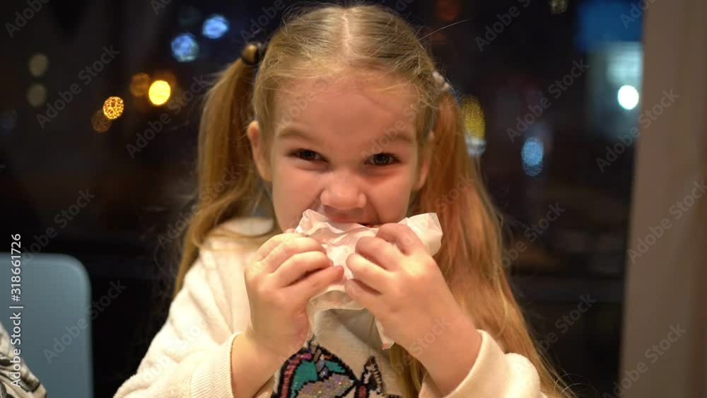 Little girl blonde with tails eats a pancake. Close-up. Little girl blonde with tails eats a pancake. Close-up.