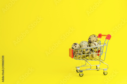 quail eggs in a grocery cart on yellow background