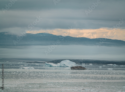 Greenland Glacier with Sea Ice and a Glacial Landscape near the Eqip Sermia Glacier, Eqi in Western Greenland near arctic town of Ilulissat. Blue sky on a sunny day. Calving Glacier. photo