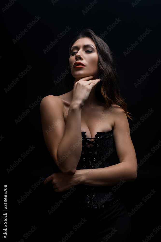 Sensual woman with hand by chin looking away isolated on black Sensual woman with hand by chin looking away isolated on black