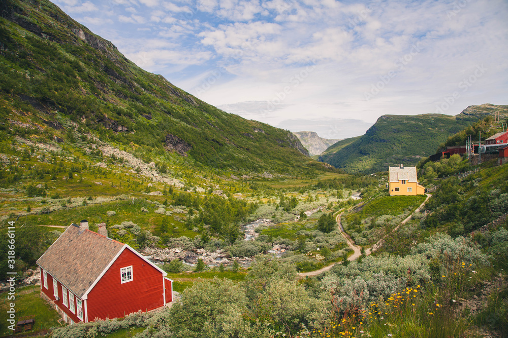 Single red house in a valley in Norway. Mountains. 
