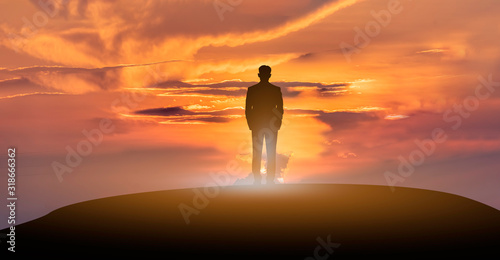Success business people standing on the top mountain look into the future at sunrise.