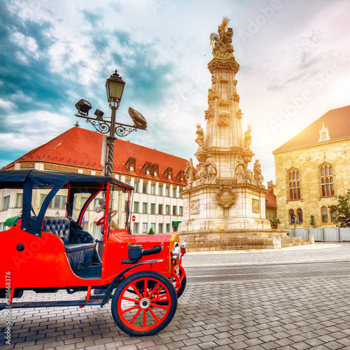 Vintage car on the background Holy Trinity Column or plague column in Fishermans Bastion. photo