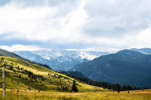 Landscape with mountains, green hills and cloudy sky, Transalpina road, Romania. © Sulugiuc