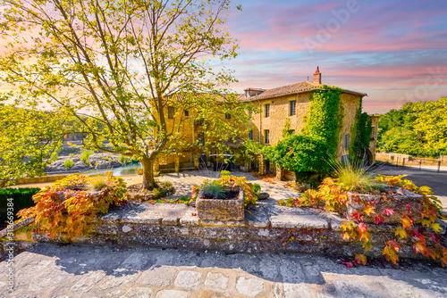 Tablou canvas A colorful sky and sunset over a historic stucco mansion or country home along a river in the Provence area of Southern France at Autumn