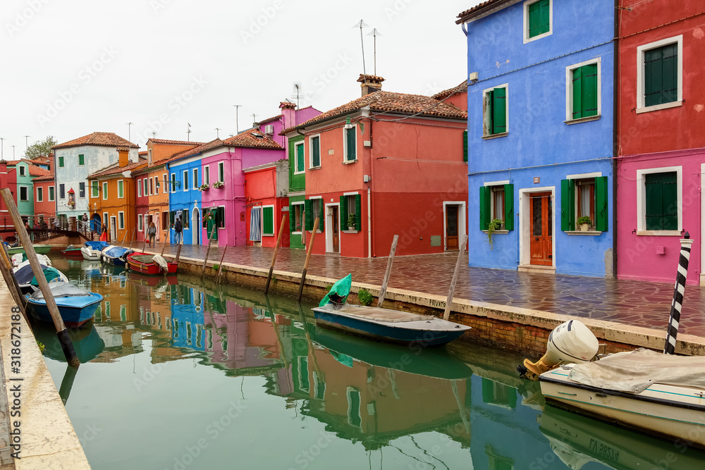 Venice landmark, Burano island canal, colorful houses church and boats, Italy.