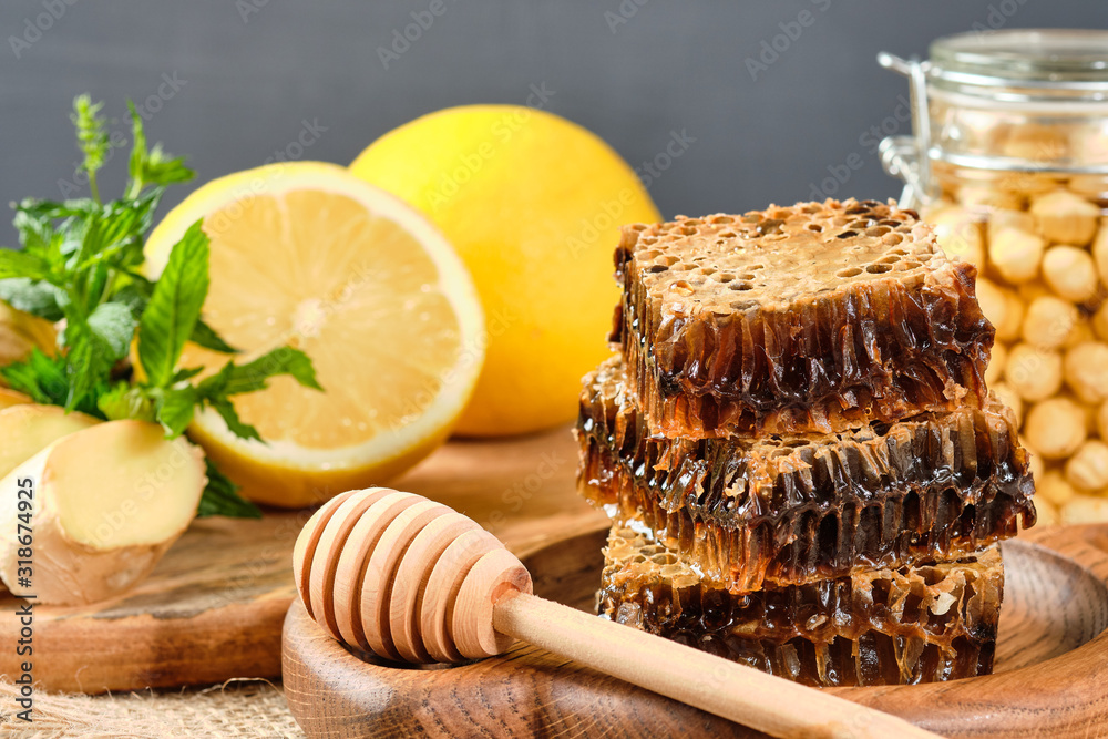 honey in honeycombs on a wooden plate and honey with nuts with lemon and ginger in rustic style on a wooden background. honey in honeycombs on a wooden plate and honey with nuts with lemon and ginger in rustic style on a wooden background.