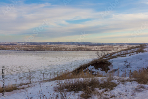 Fototapeta Naklejka Na Ścianę i Meble -  Beautiful winter landscape in the hill. Frozen lake landscape showing city in the distance. Russian Winter.