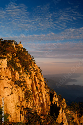 Visitor on Lion Peak at sunrise with fog in valley at Huangshan Mountain China