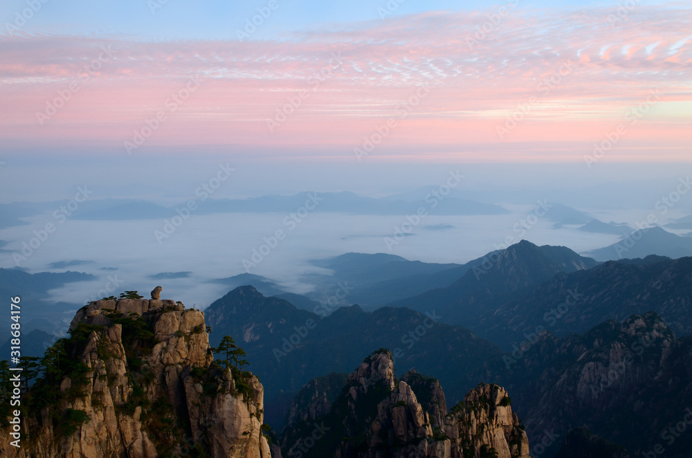 Obraz premium Sunrise red sky at Monkey watching the Sea Peak with fog in valley at Huangshan Mountains China