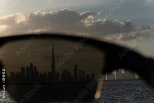 Closeup view trough sunglasses to the amazing silhouette of Dubai, UAE. 