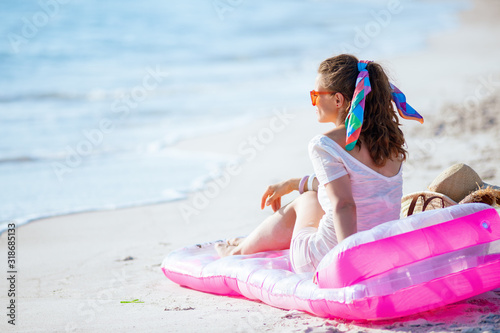 woman on ocean coast sitting on inflatable mattress