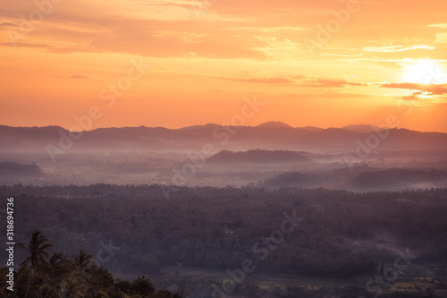Sunset valley foggy landscape with fog in the early morning on valley with tropical forest on Bali Indonesia