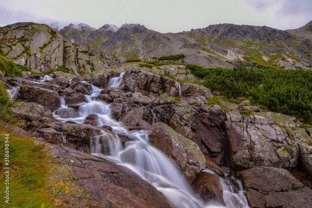 between the rocks of the mountain stream below the ridge between the rocks of the mountain stream below the ridge