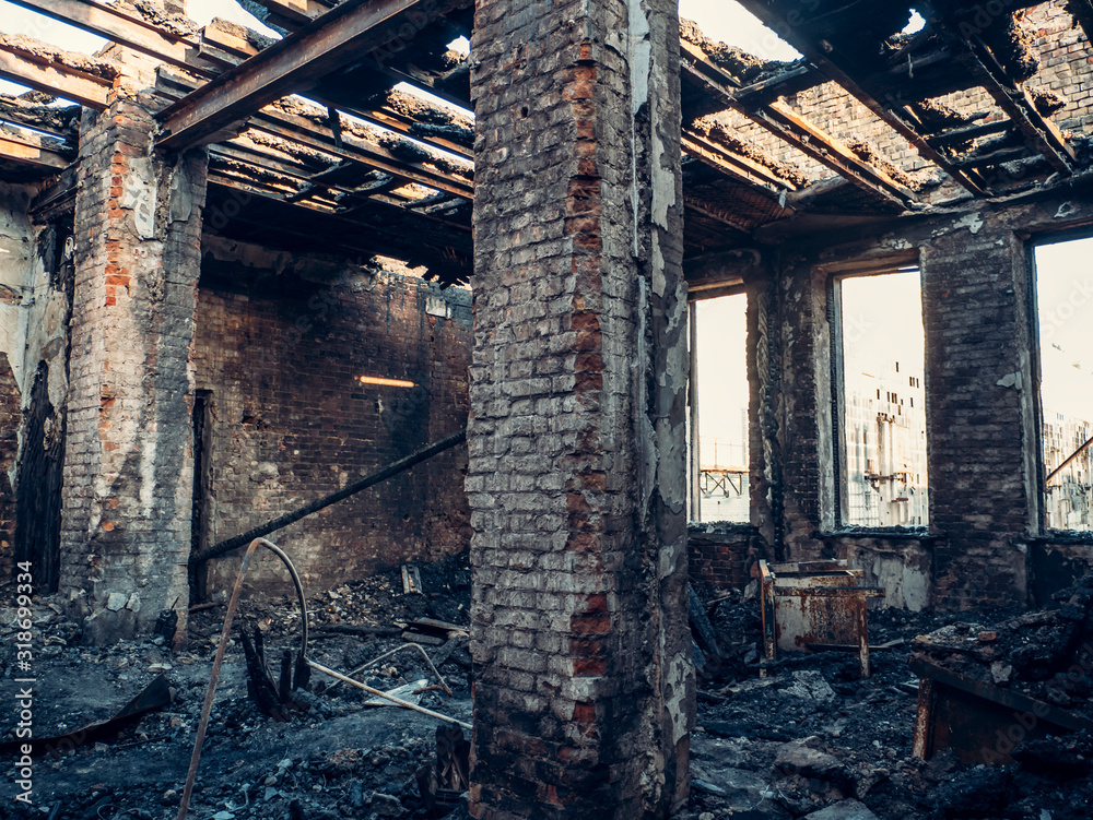 Burnt house interior inside, burned ruined room, remains of furniture in black soot on floor. Fire or war consequences concept.